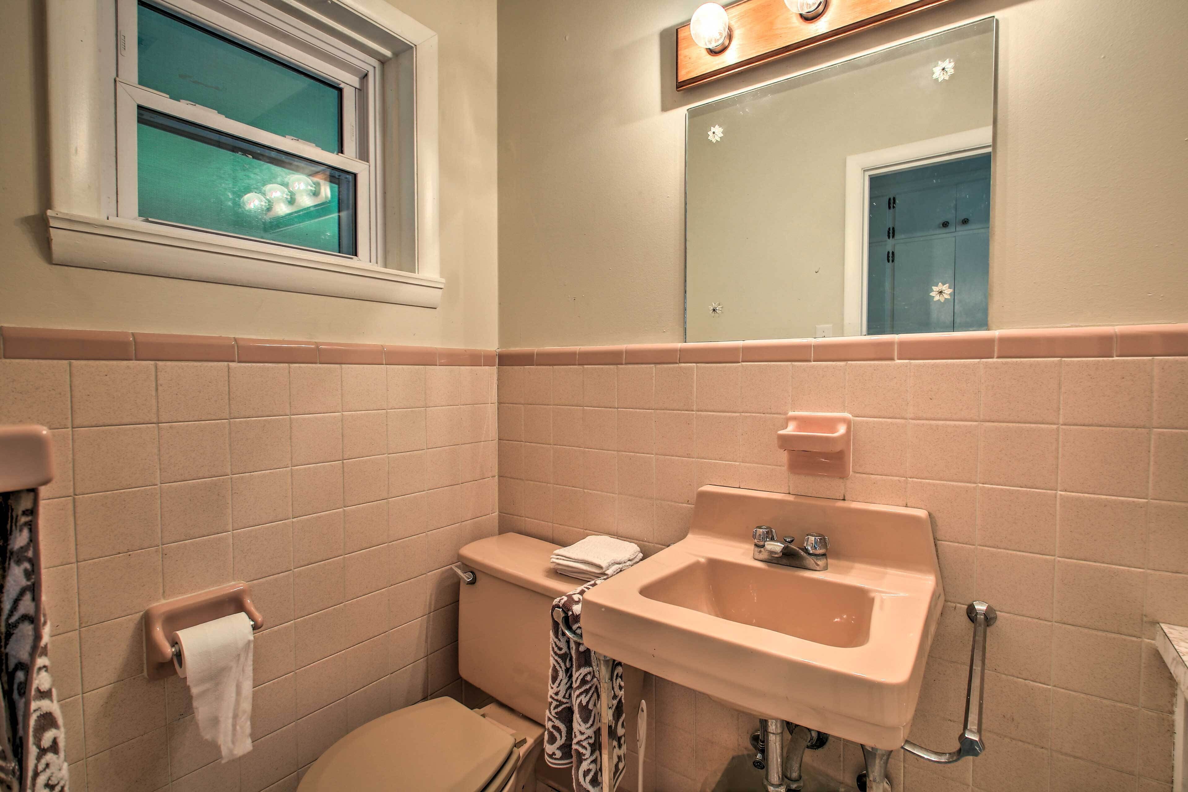 Une salle de bain avec des toilettes, un lavabo et un miroir.