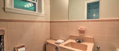 Une salle de bain avec des toilettes, un lavabo et un miroir.