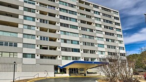 Ein mehrstöckiges Hotel mit einem gemusterten Fassadengestaltung, einem überdachten Eingangsbereich und einem Parkplatz.