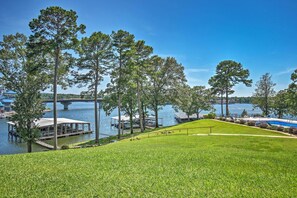 A lakeside view with a grassy area, docked boats, and a bridge in the background. - Views & Pool Access: Quaint Condo in Hot Springs! (Hot Springs)