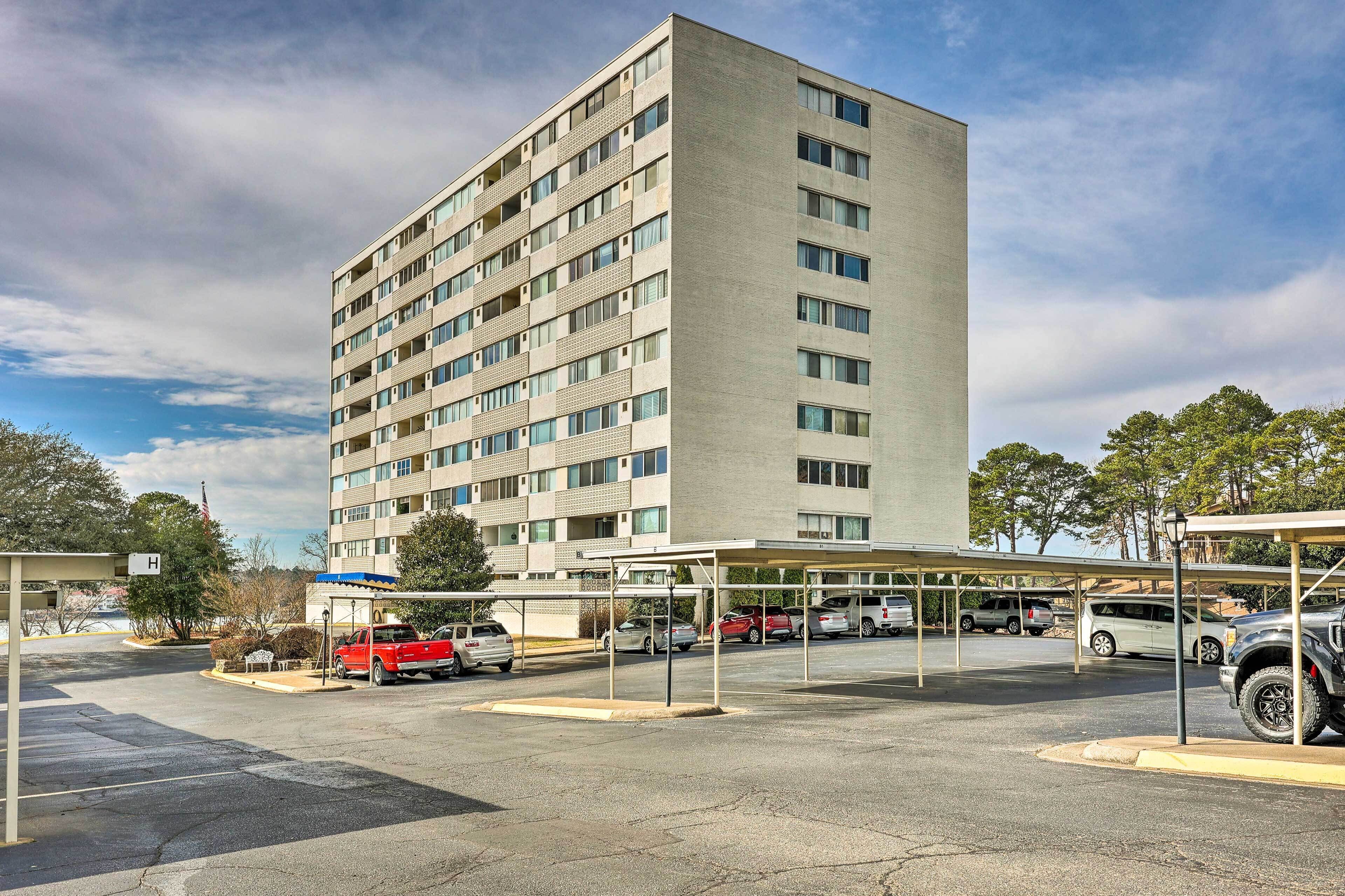 Un hotel de varios pisos con estacionamiento y estructuras de estacionamiento cubiertas.