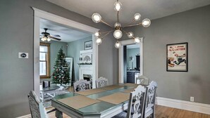 Una sala da pranzo con un tavolo grande, sedie, un lampadario e un albero di Natale.