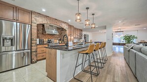 A modern kitchen with a central island, stainless steel appliances, and a brick backsplash. - Outdoor Oasis! Group Getaway w/ Pool in Brandon (Brandon)