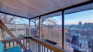A covered outdoor area with a wooden deck, a view of a cityscape, and a building with a unique dome structure. - Cincinnati Home, Patio w/ Downtown Views! (Cincinnati)
