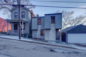 A two-story house with a garage, a porch, and a driveway. - Cincinnati Home, Patio w/ Downtown Views! (Cincinnati)