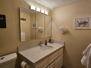 A bathroom with a large mirror, a sink, and a toilet. - Best view in Maui. Condo fully remodeled. (Wailuku)