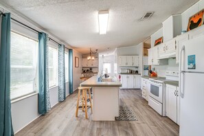 A kitchen with a central island, wooden flooring, white cabinetry, and a built-in oven. - 5 Mi to Homosassa Springs Park: Home w/ Yard! (Homosassa)