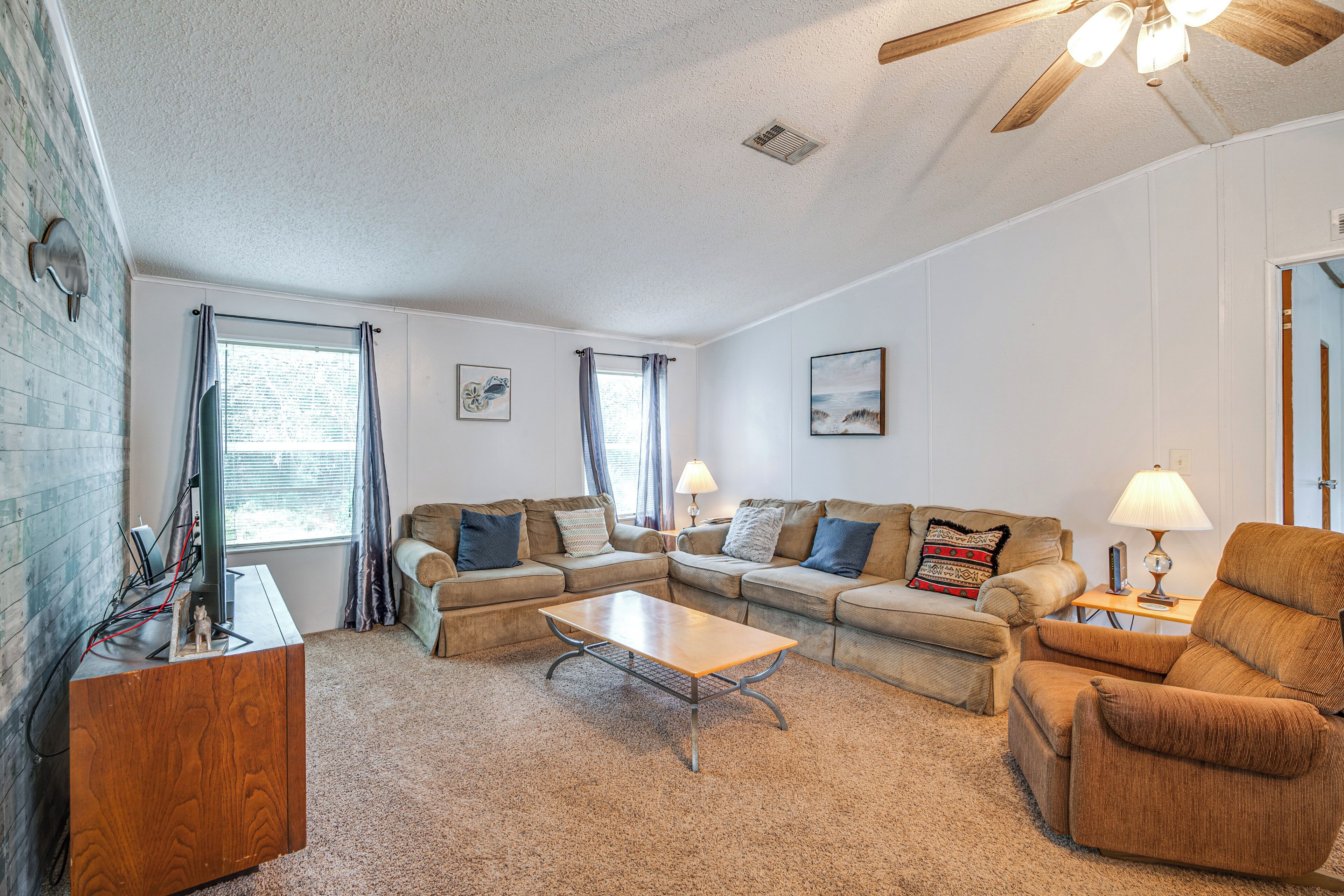 A living room with a sectional sofa, a coffee table, and a wooden side table.