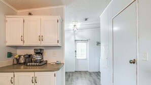 A kitchen with white cabinets, a coffee maker, and a window with blinds. - 5 Mi to Homosassa Springs Park: Home w/ Yard! (Homosassa)