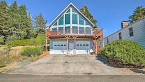 Une maison à deux étages avec un grand garage, un balcon et une pelouse bien entretenue.