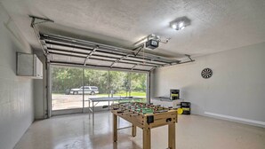 Un garaje con una mesa de fútbol de mesa, un dardo y una cámara de seguridad.