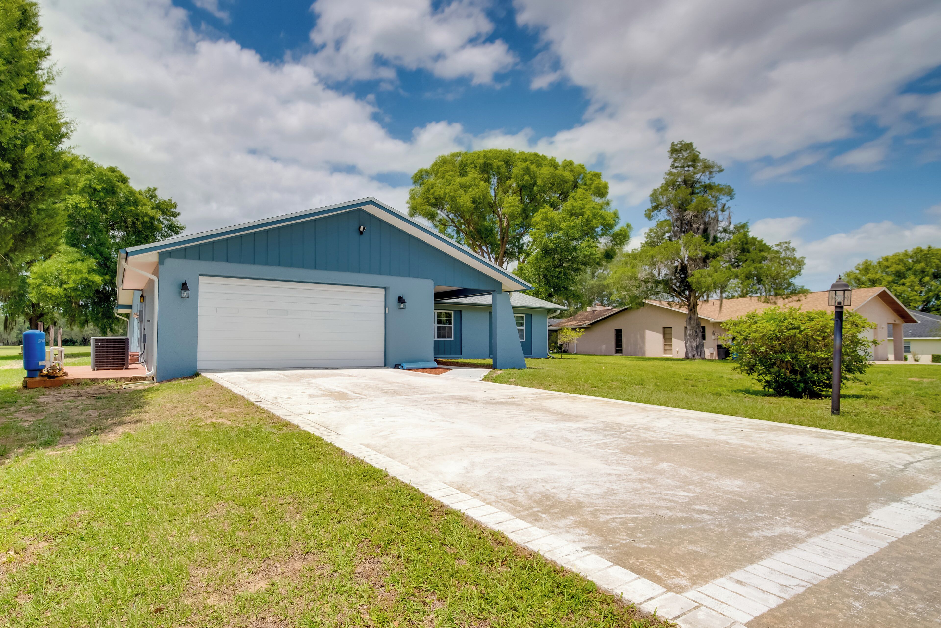 A residential house with a garage, a driveway, and a lawn.