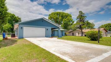 A residential house with a garage, a driveway, and a lawn.