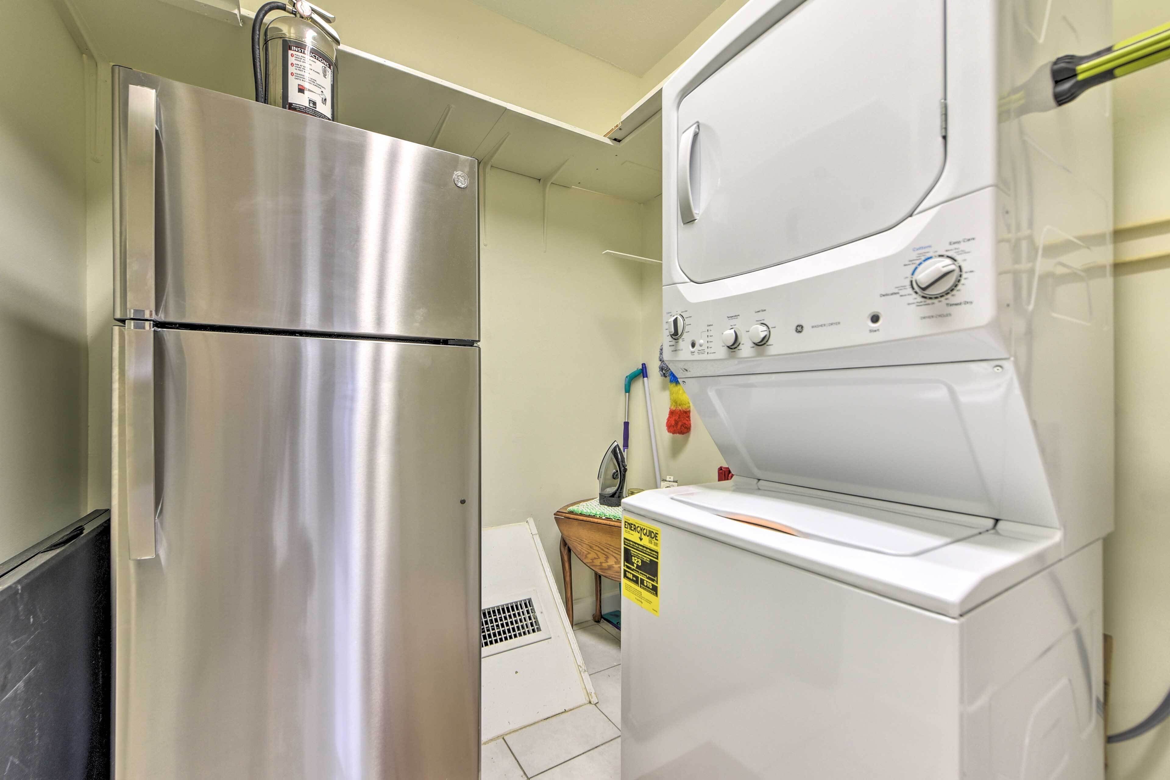 Eine kompakte Küche mit einem Edelstahl-Kühlschrank sowie einer integrierten Waschmaschine und einem Trockner.