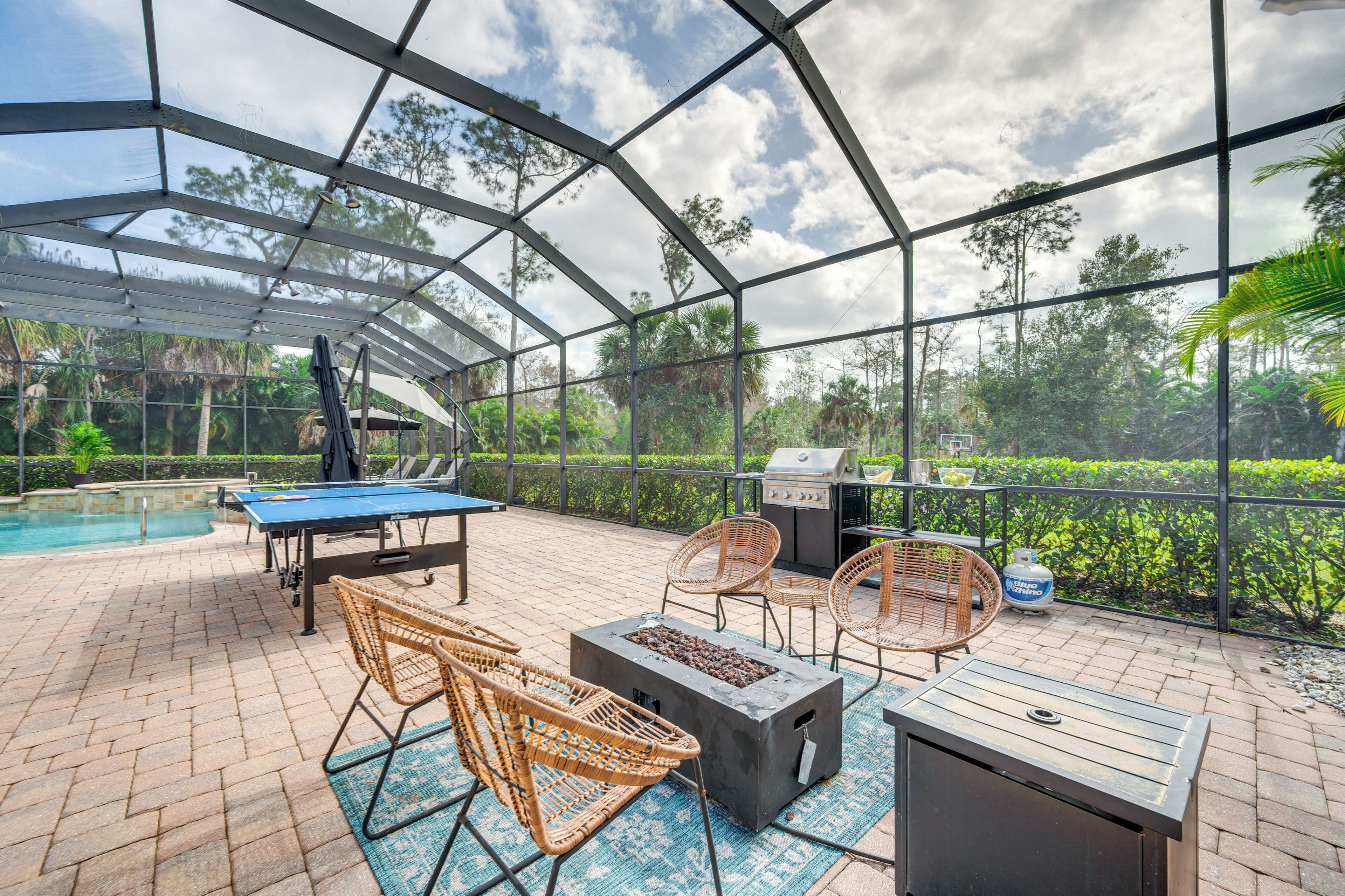 A covered outdoor area with a pool table, lounge chairs, and a barbecue grill.