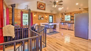 A modern log cabin interior with a dining area, kitchen, and a staircase. - 24-0132 Alma Retreat w/ Deck: 17 Mi to Skiing (Alma)