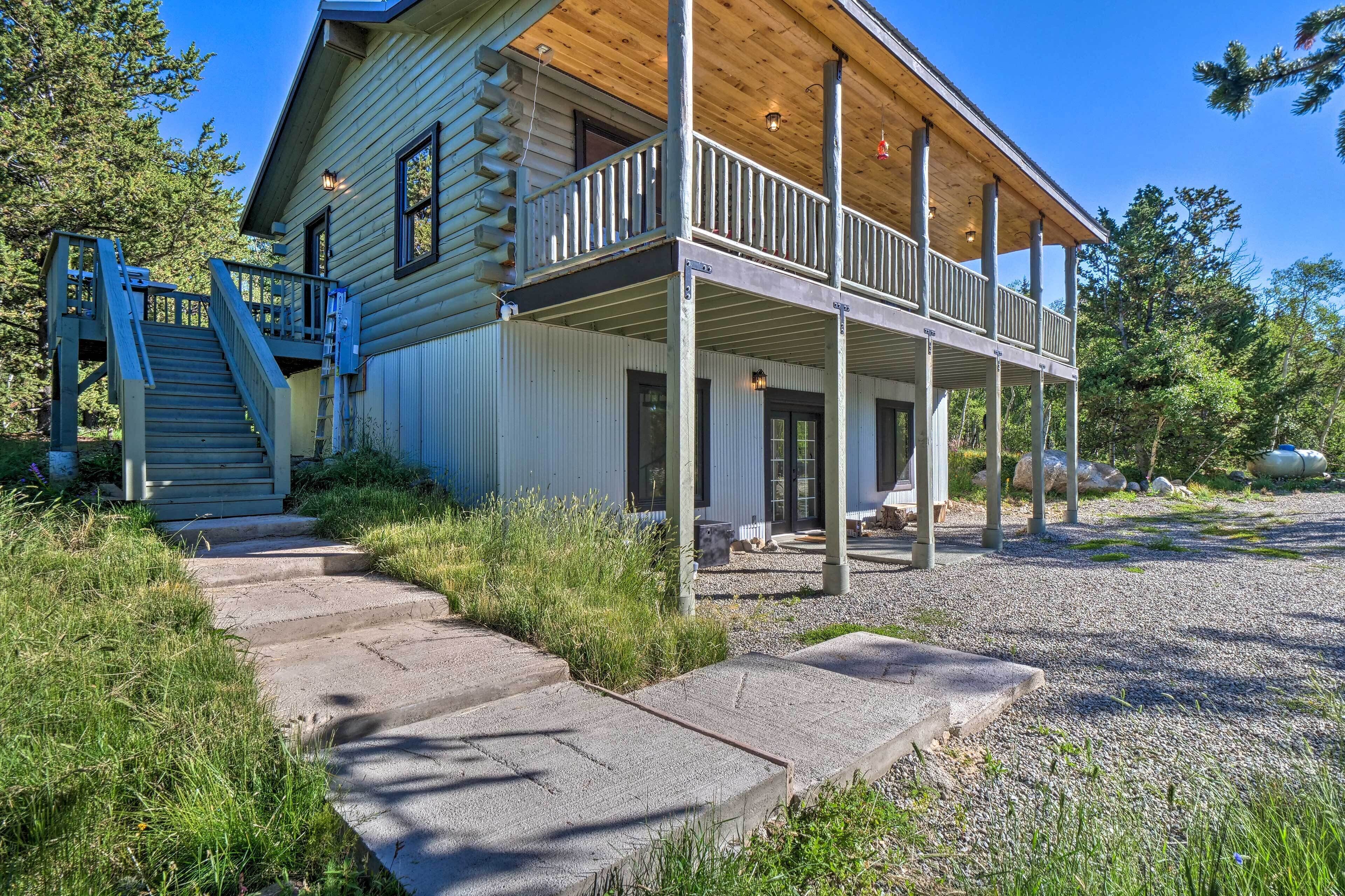 A log cabin with a wooden porch and a staircase leading to the entrance.