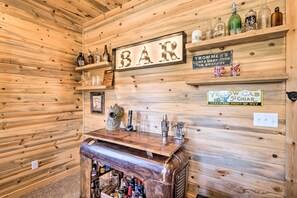 A wooden interior with a bar area featuring a sign that reads "BAR," shelves with bottles, a vintage cash register, and a sign for "Yellow Cab 5¢ Cigar." - Jefferson Cabin w/ Fire Pit: Near Hiking Trails! (Como)