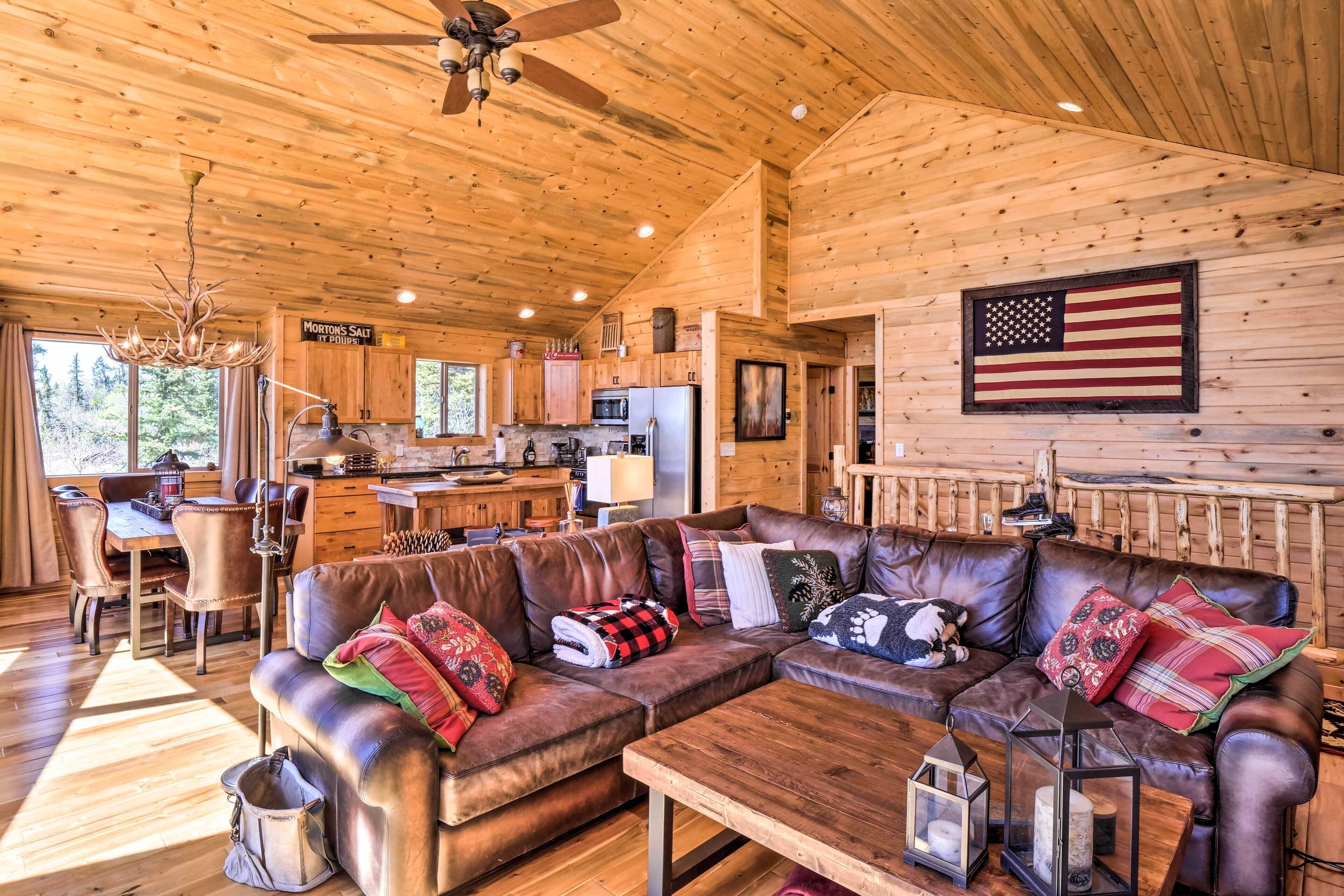 Une cabane en bois spacieuse, dotée d’un grand salon, d’une cuisine et d’un coin repas.