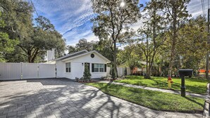 A residential property with a paved driveway, a white house, and a well-maintained lawn. - Pet-friendly Mt Dora Home w/ Fire Pit & Patio (Mount Dora)