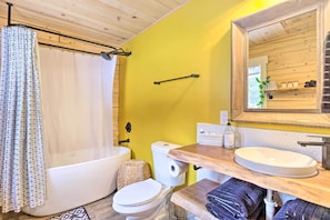 A bathroom with a bathtub, toilet, and sink. - Picturesque Alma Log Cabin w/ Deck & Grill! (Alma)