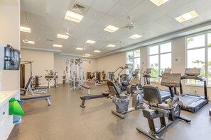 A gym with various exercise equipment, large windows, and a ceiling with multiple light fixtures. - Sunny Ocean Village Beach Condo: Community Pool (Fort Pierce)