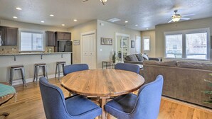 A spacious kitchen with a central island, bar stools, and a ceiling fan. - Charming Boise Home ~ 8 Mi to Downtown! (Garden City)