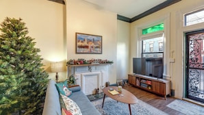 A cozy living room with a fireplace, a television, a Christmas tree, and a sofa. - Cincinnati Retreat w/ Patio & Grill! (Cincinnati)