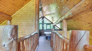 A wooden interior with a high ceiling and a central aisle leading to a window. - Gatlinburg Vacation Rental w/ Hot Tub & Game Room! (Gatlinburg)
