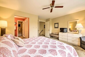 A bedroom with a large bed, a ceiling fan, a dresser, a TV, and a door leading to another room. - Niceville Condo w/ Pool Access < 8 Mi to Destin! (Niceville)