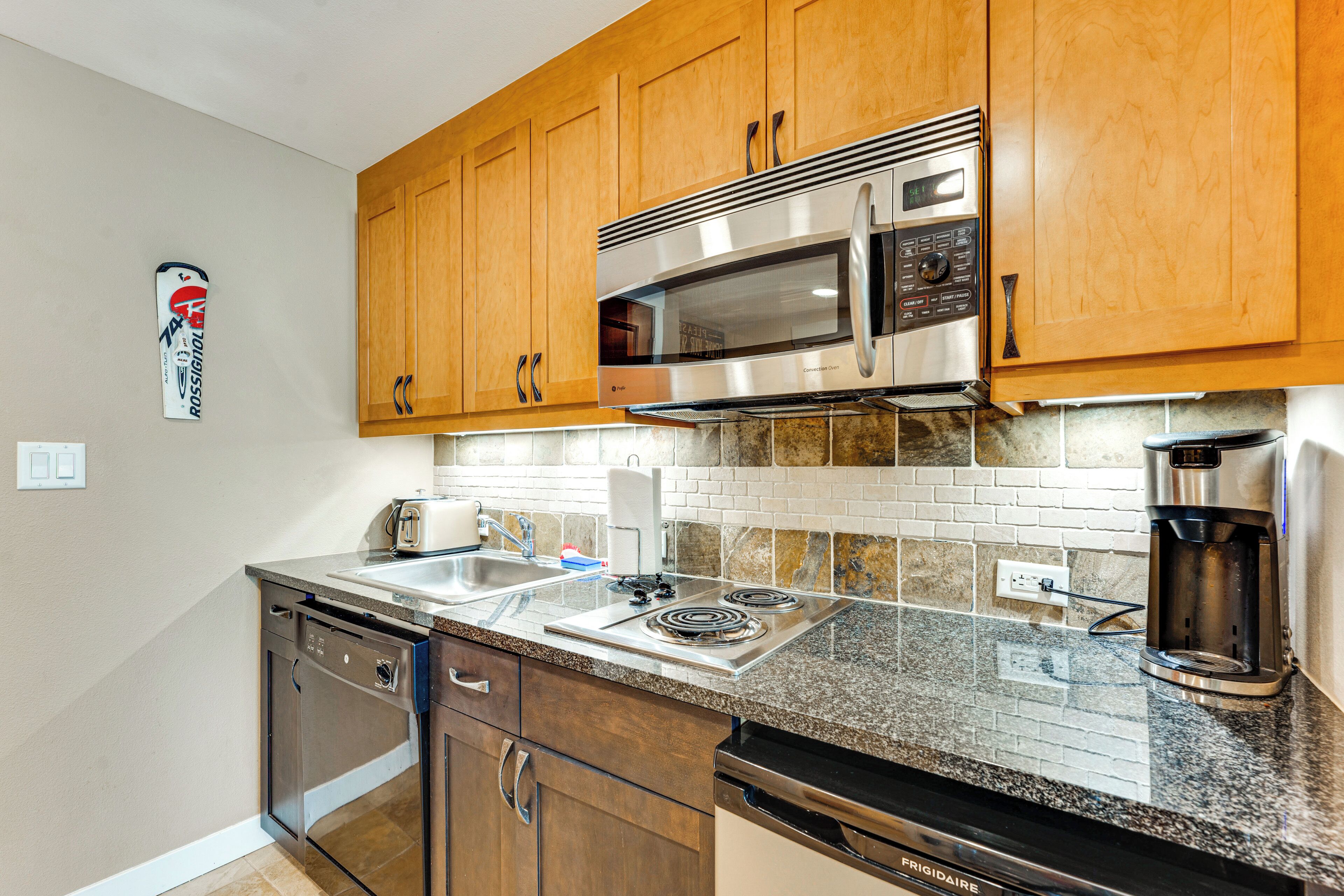 A kitchen with wooden cabinets, stainless steel appliances, a dishwasher, and a coffee maker.