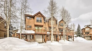 A multi-story wooden lodge with a snow-covered driveway and surrounding trees. - Winter Park Townhome w/ Hot Tub, Ski Shuttle! (Winter Park)