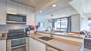 A modern kitchen with stainless steel appliances, a wooden countertop, and a large window offering a view of the outdoors. - Walkable Winter Park Condo ~ 4 Mi to Slopes! (Winter Park)