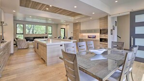 A modern kitchen with a central island, wooden flooring, and large windows. - Luxurious Home, Walk to Beaver Creek Gondola! (Avon)