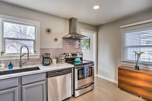 A modern kitchen with a stainless steel dishwasher, double oven, and a coffee maker on the counter. - Grand Junction Vacation Rental w/ Fire Pit! (Grand Junction)