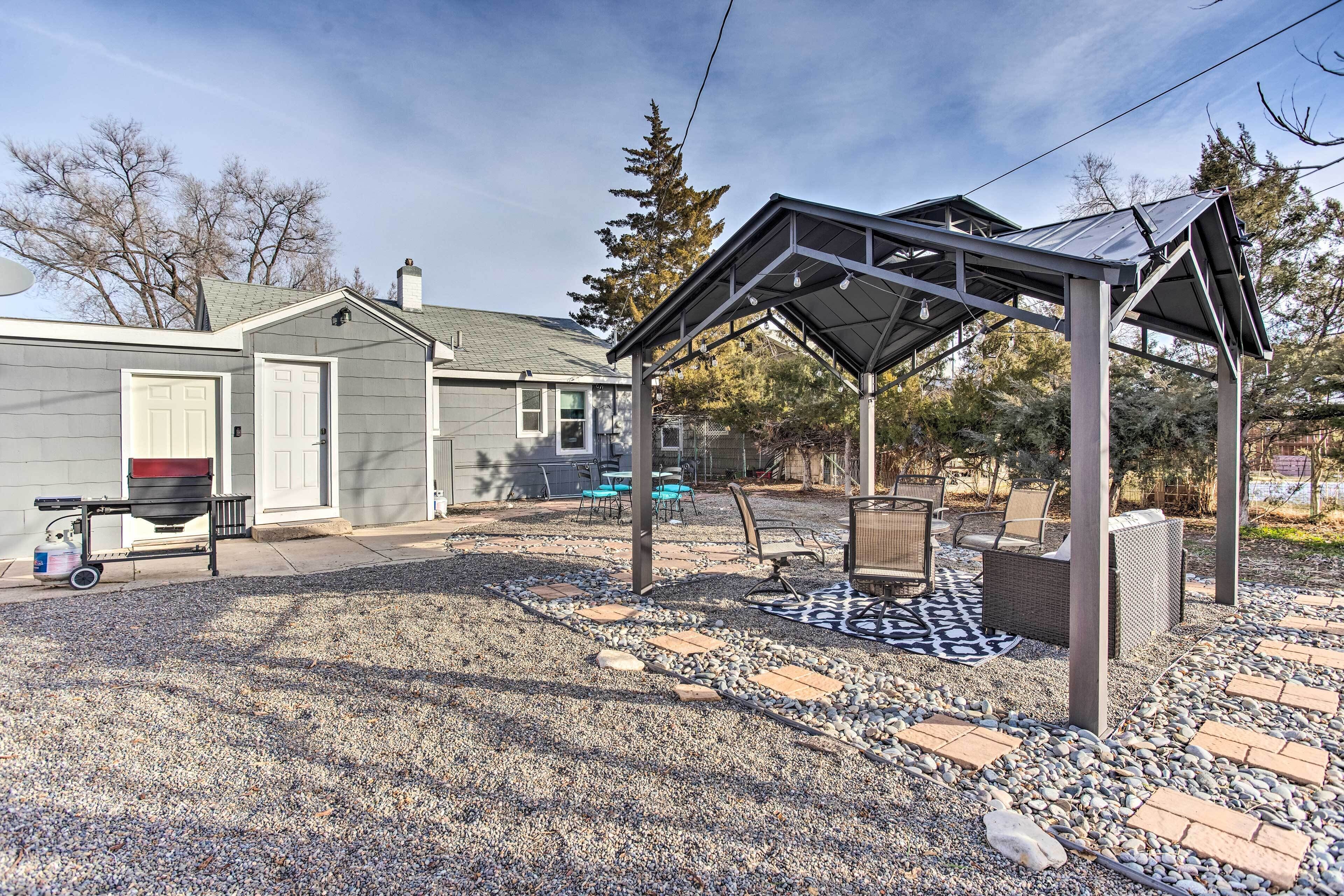 A covered patio area with outdoor seating and a grill.