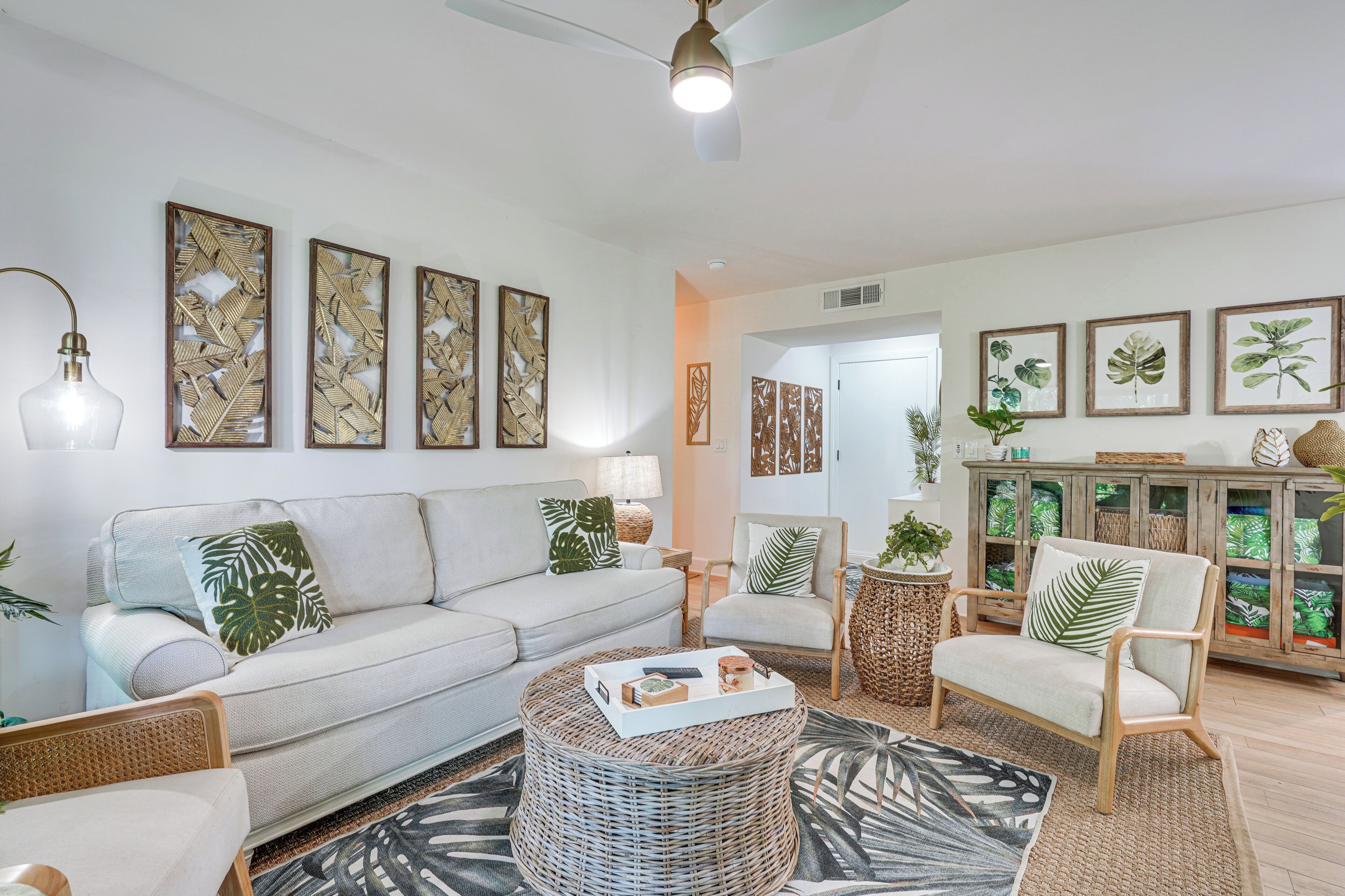 Un salon comprenant un canapé, des fauteuils, une table basse et des éléments décoratifs muraux.