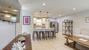 A modern kitchen with a central island, bar stools, and pendant lighting. - < 3 Mi to Juno Beach: Coastal Townhome w/ Patio! (Juno Beach)