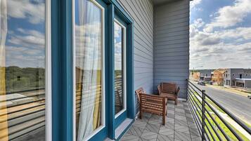 Enjoy the view from this balcony with a street view, featuring a tiled floor and comfortable seating area.