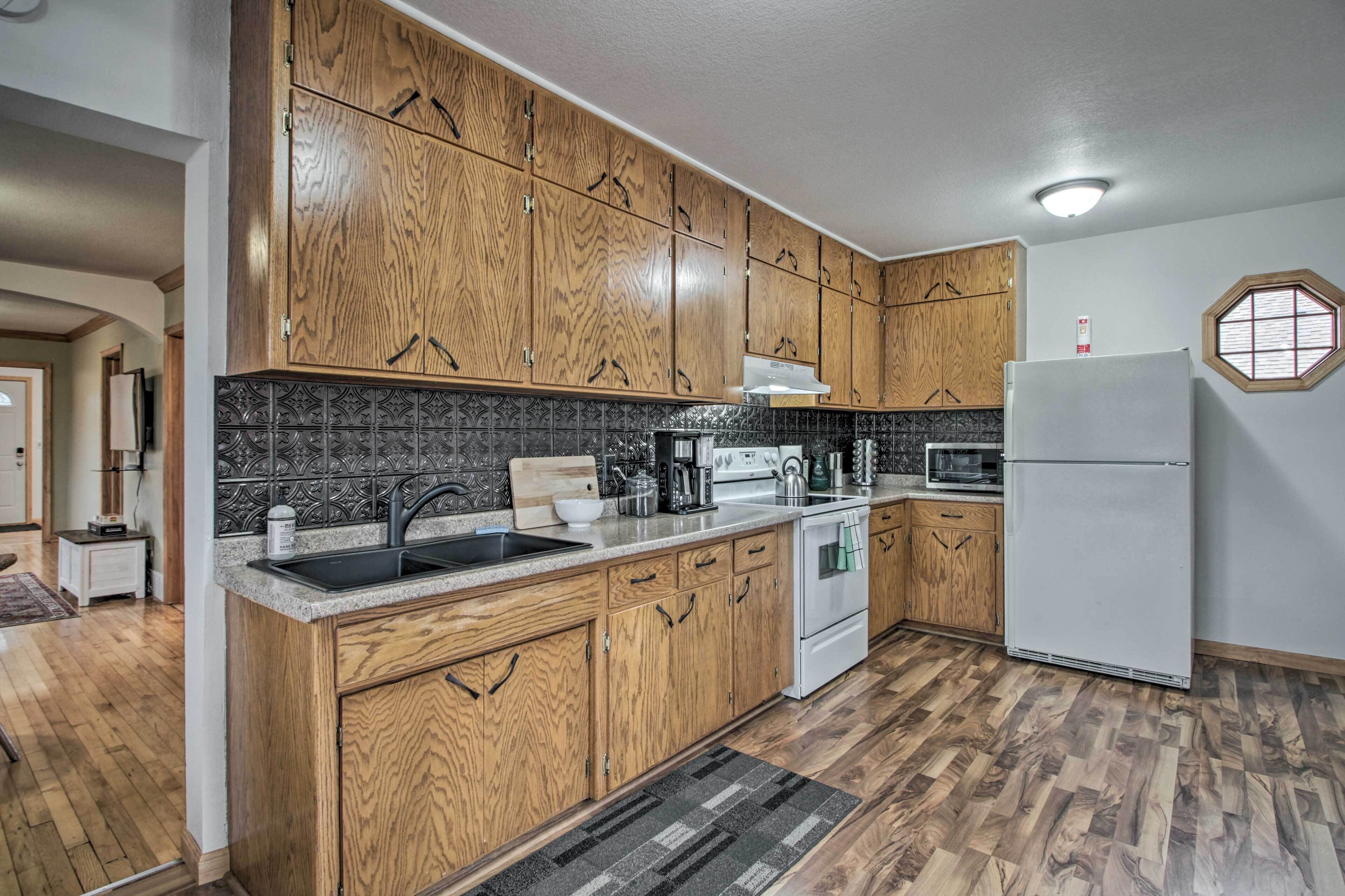 Una cocina con armarios de madera, un refrigerador blanco y un salpicadero de azulejos.