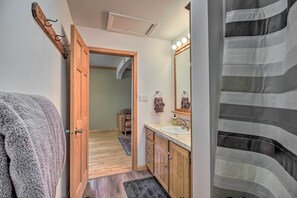 A bathroom with wooden cabinets, a sink, and a mirror with lights. - Dog-friendly Crosby Home w/ Bike Storage! (Crosby)