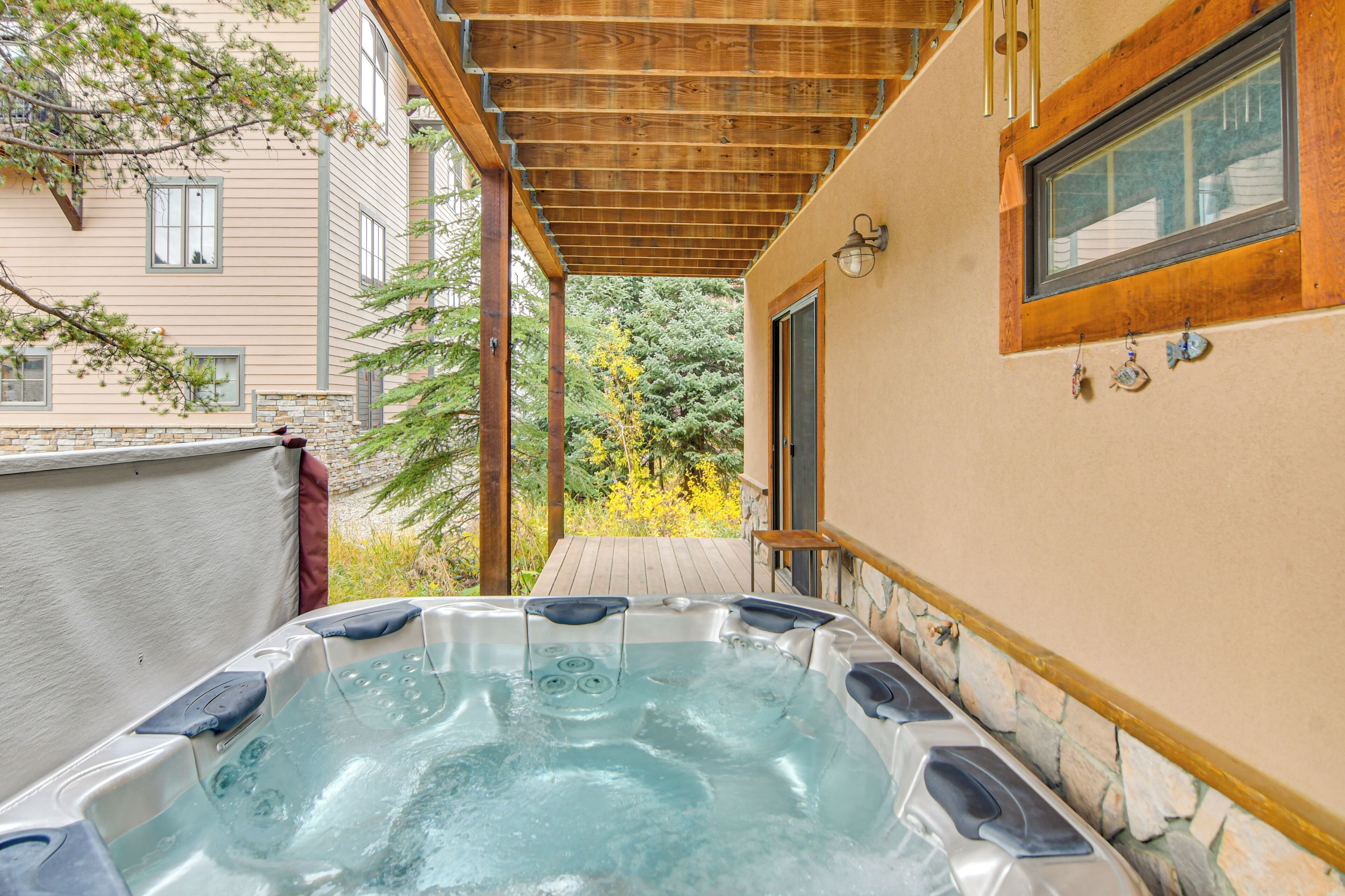 A hot tub in a covered outdoor area with a wooden ceiling and stone walls.
