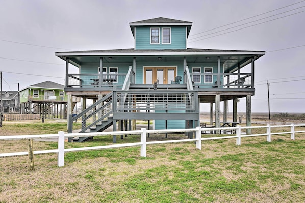 A two-story house with a balcony and a staircase leading to the upper floor. - Idyllic Gulf Coast Escape: Steps to Surfside Beach (Freeport)