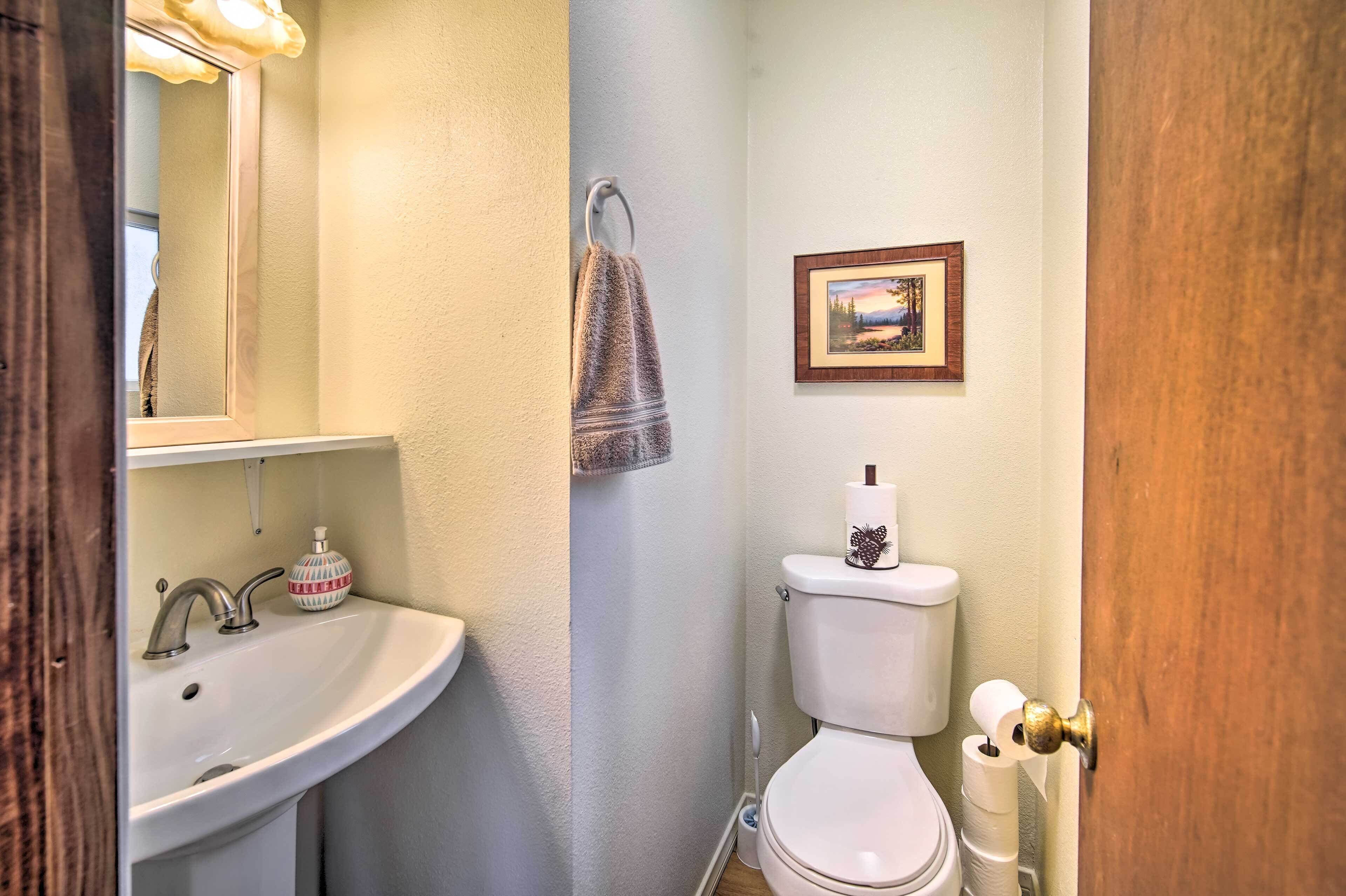 Een badkamer met een wastafel, toilet en een foto in een lijst aan de muur.