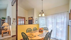 A dining area with a wooden table, chairs, and a chandelier. - 3 Mi to Skiing: Big Bear Cabin w/ Deck (Big Bear City)