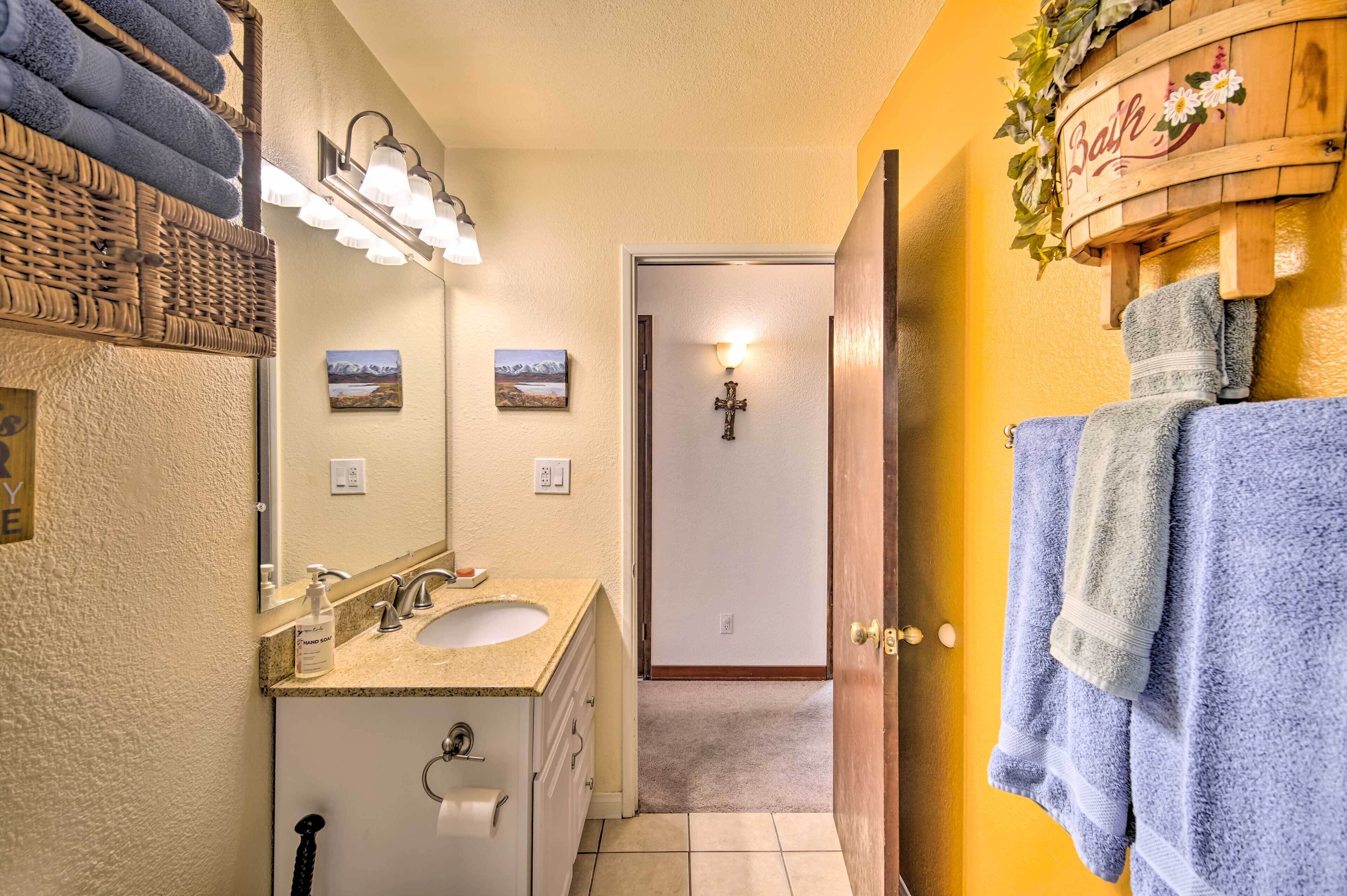 A bathroom with a sink, mirror, and towel rack.