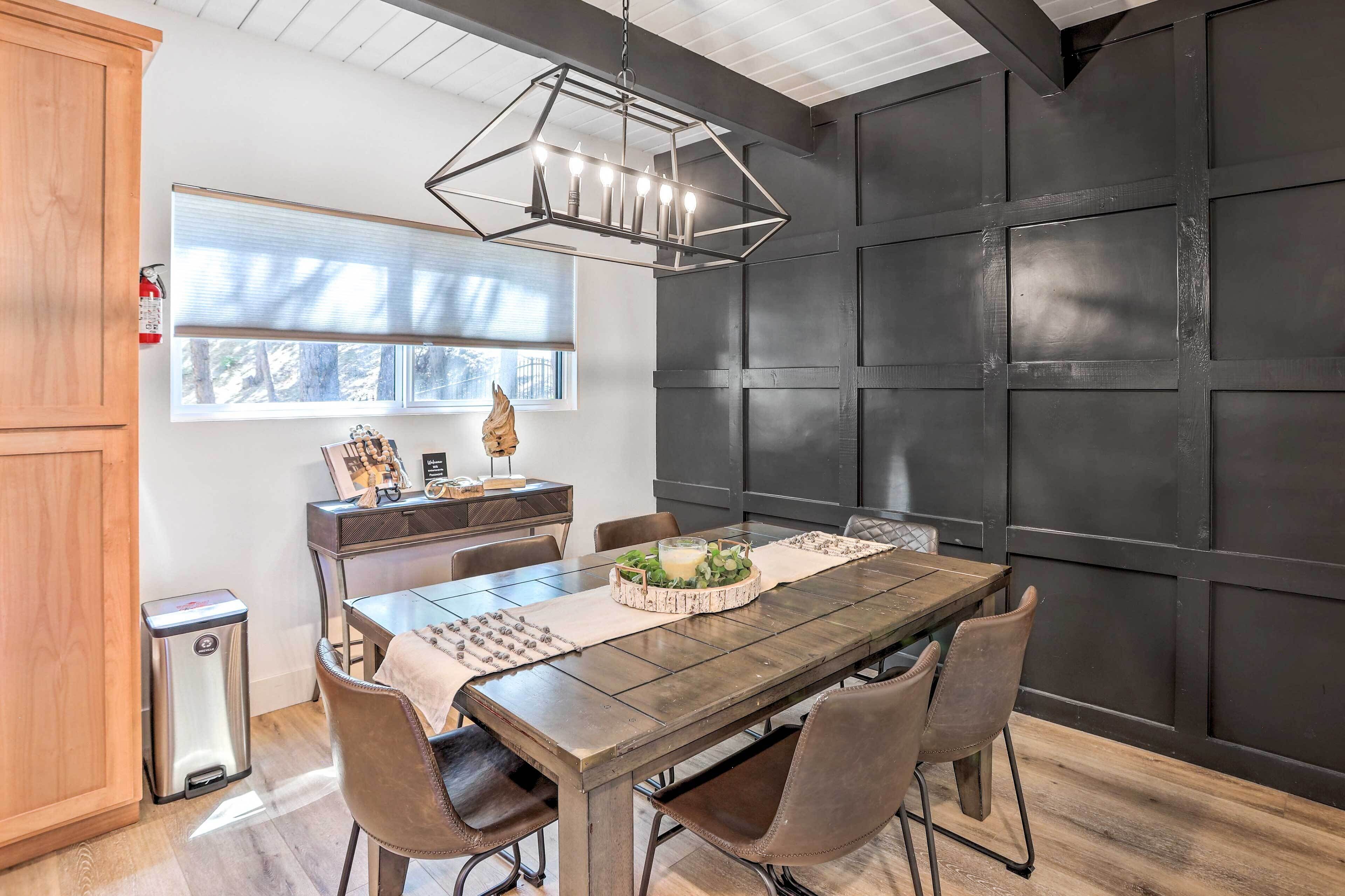 Un coin repas avec une table en bois, des chaises et une suspension moderne.