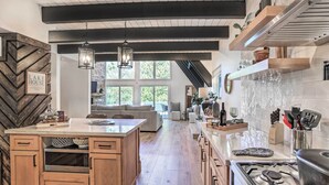 Una cocina moderna con una isla central, armarios de madera y un ventanal que proporciona luz natural.