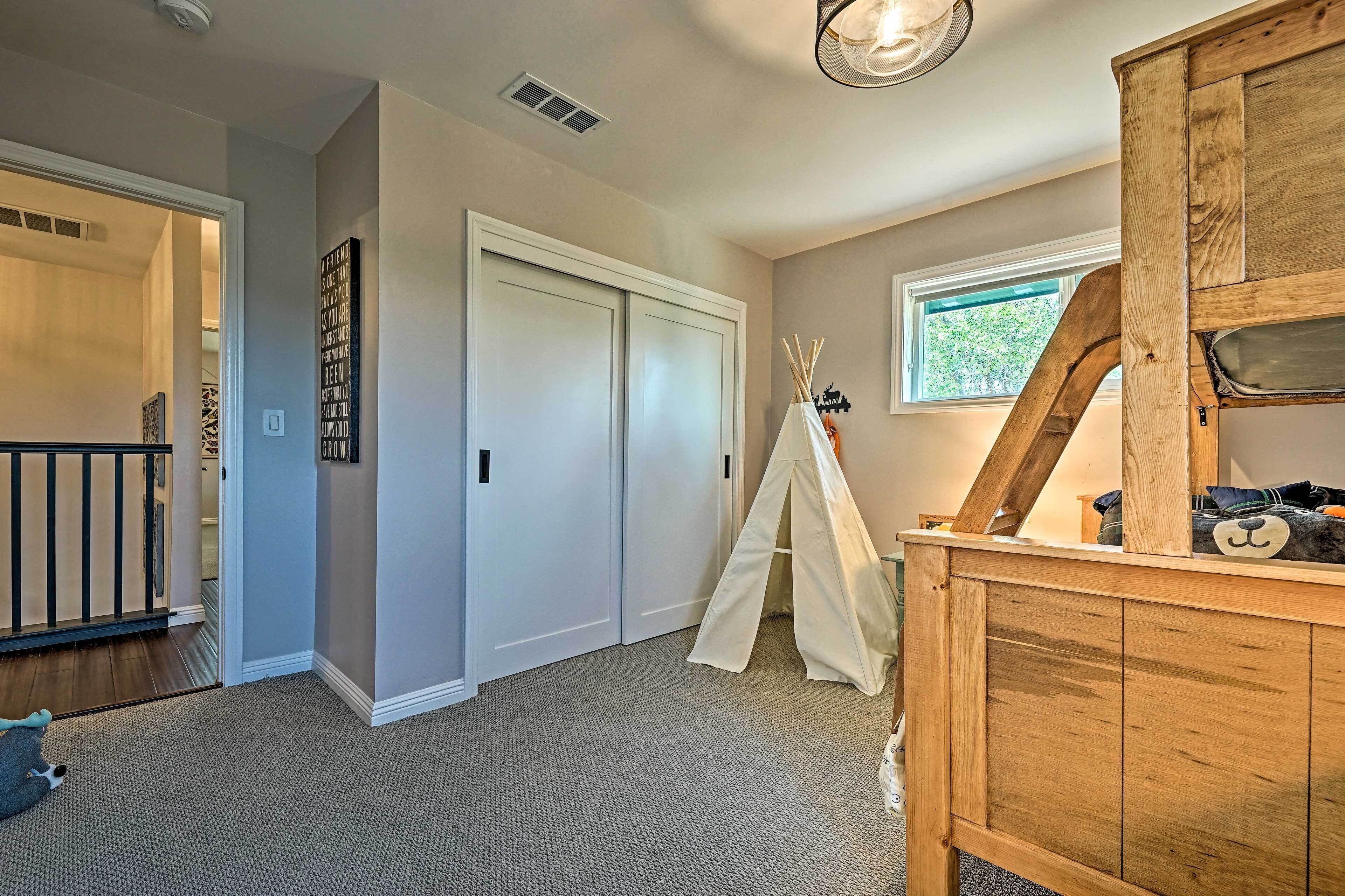 A room with a wooden cabinet, a white door, a window, and a carpeted floor.