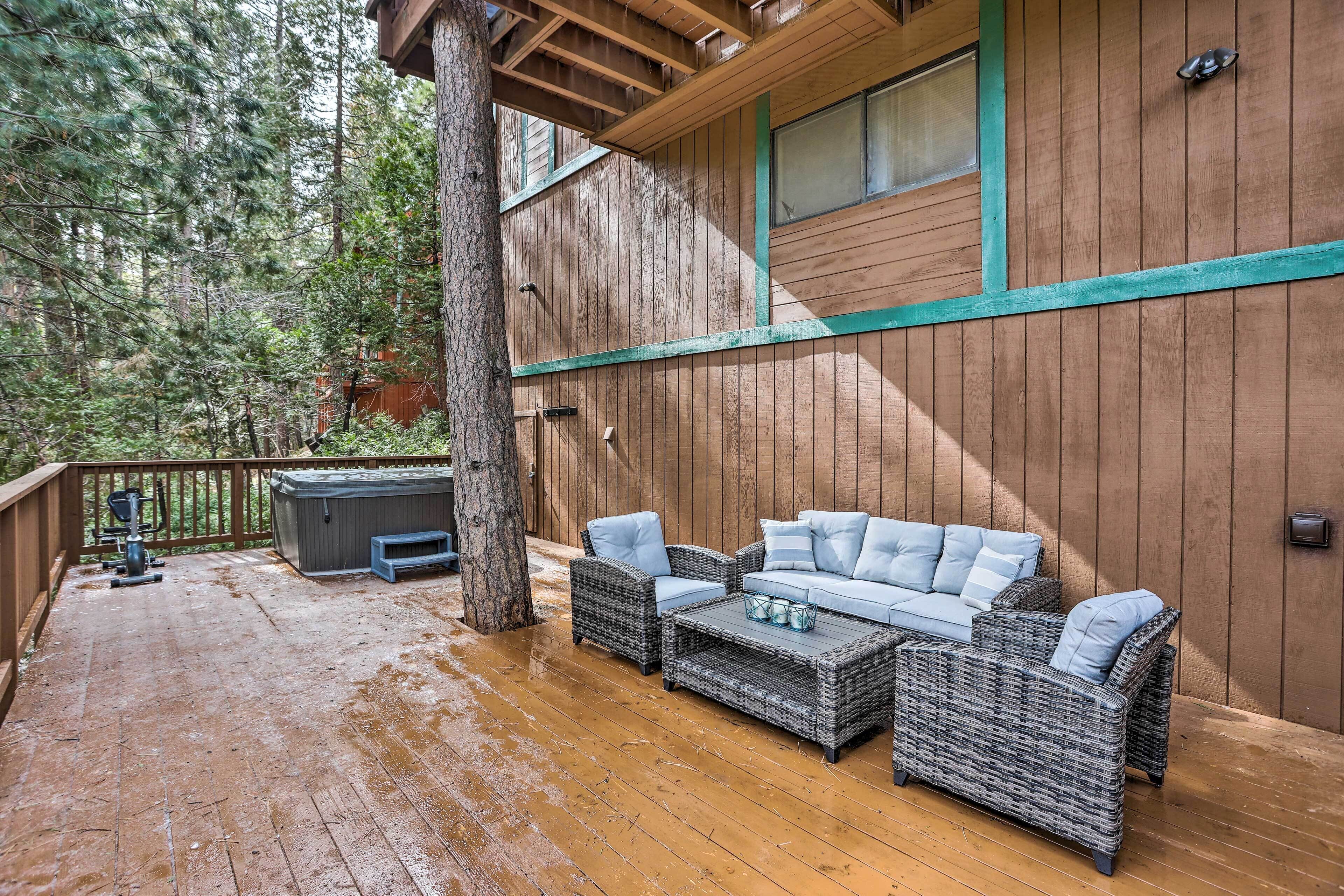 An outdoor deck with wicker furniture, a hot tub, and a wooden deck.